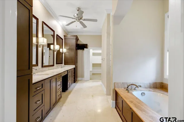 a spacious bathroom with a granite countertop tub double vanity sink and a large mirror