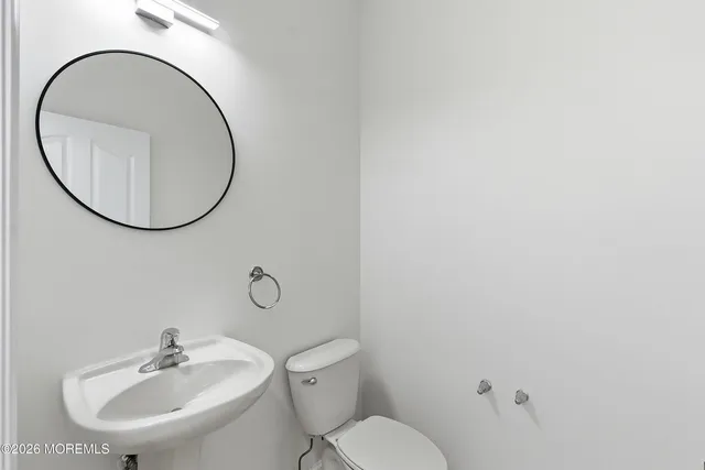 a bathroom with a toilet a sink and a mirror