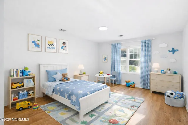 a bedroom with a bed and wooden floor