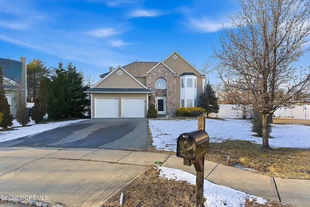 a front view of a house with garden and trees
