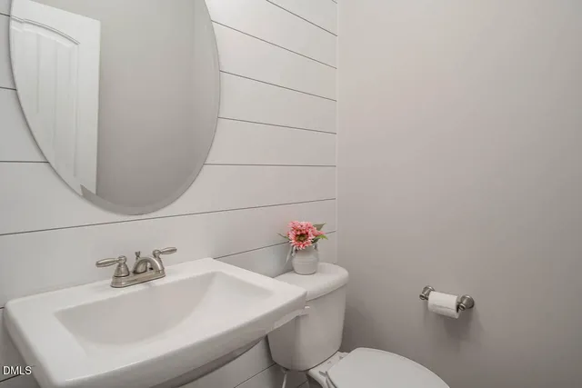 a bathroom with a sink a toilet and mirror