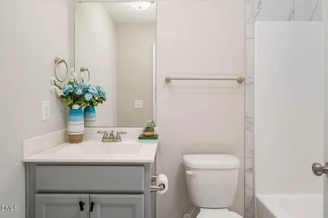 a bathroom with a sink toilet and a mirror
