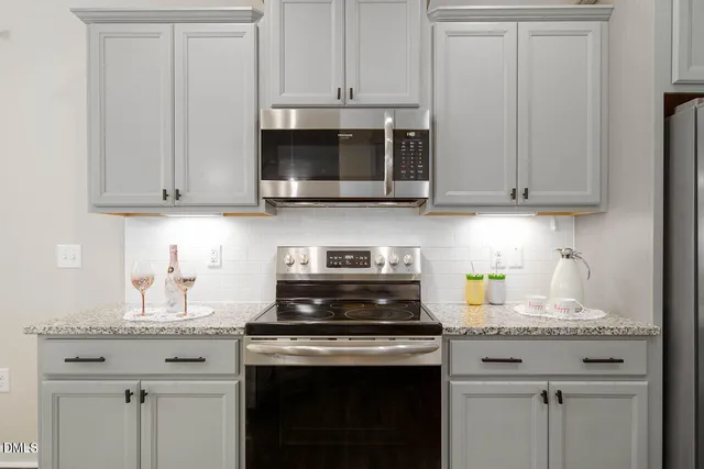 a kitchen with granite countertop white cabinets and a stove
