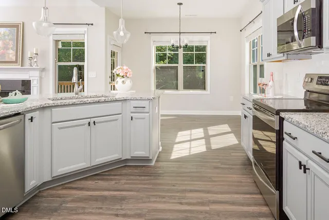 a kitchen with granite countertop a stove a sink and a refrigerator