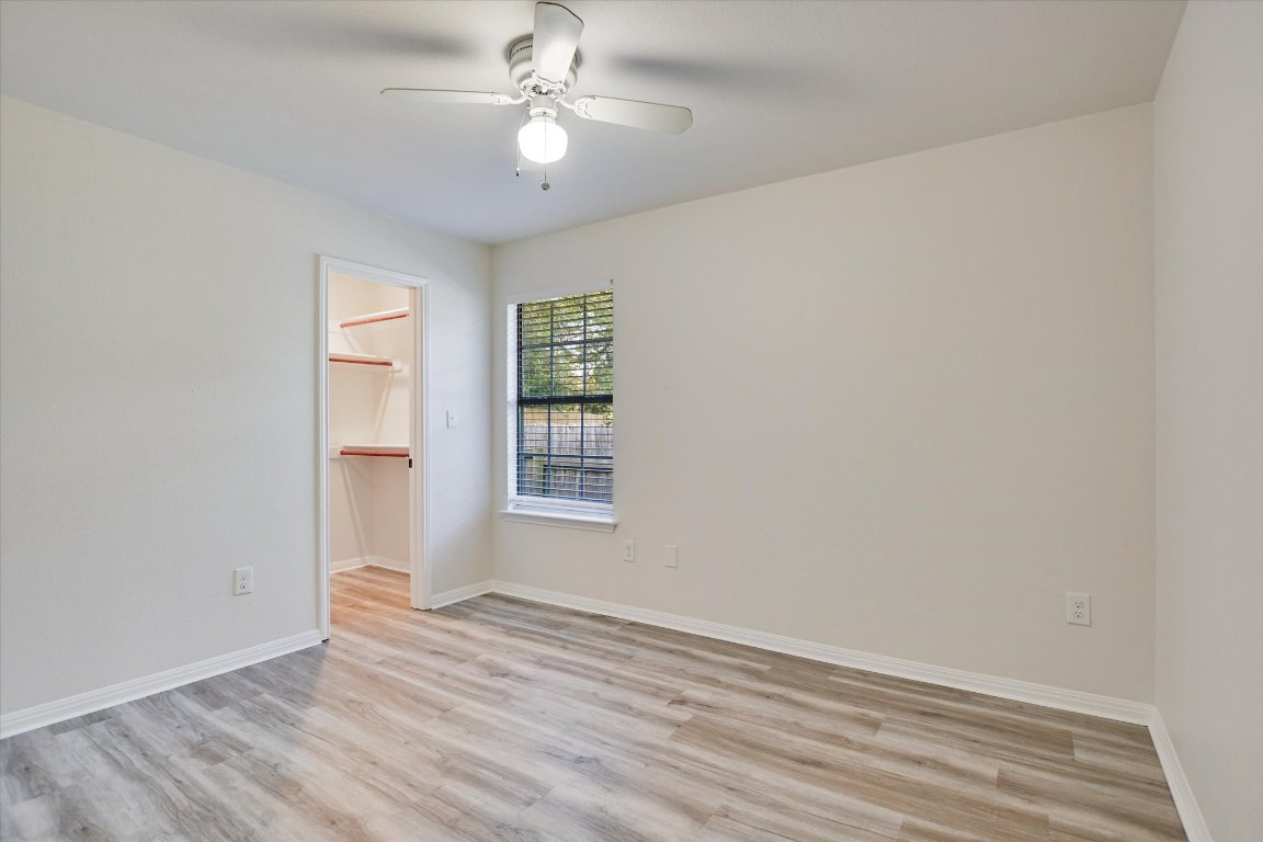 3407 Blumie Street, Unit B Austin, TX 78745 - Photo 9 of 10 an empty room with wooden floor fan and windows