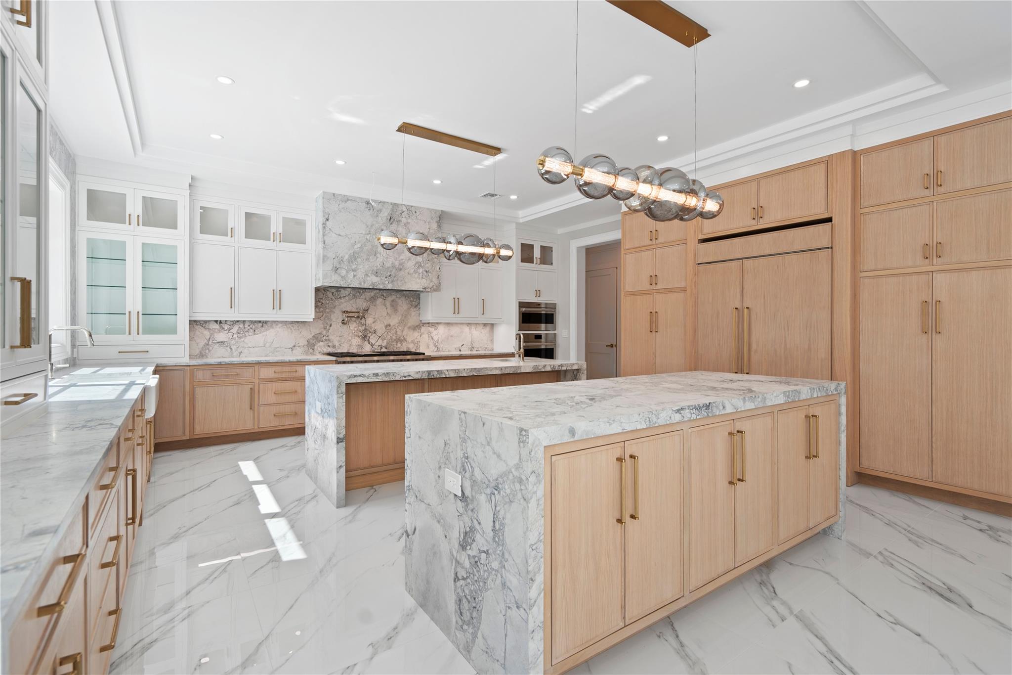20 Knollwood Road Muttontown, NY 11545 - Photo 16 of 41 Kitchen with a kitchen island with sink, light brown cabinets, a sink, and backsplash