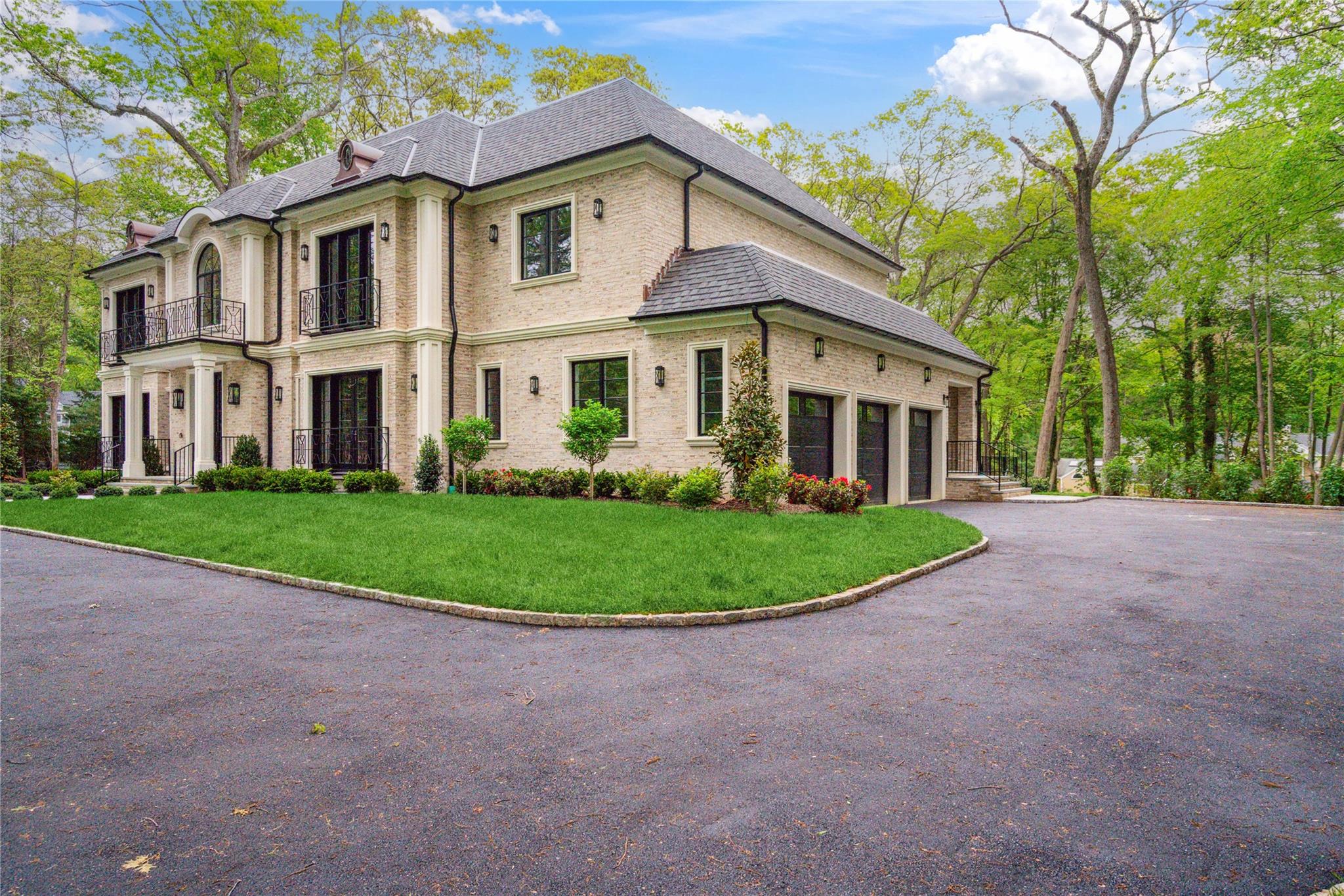 20 Knollwood Road Muttontown, NY 11545 - Photo 2 of 41 View of front of home featuring a balcony, brick siding, asphalt driveway, a front lawn, and a shingled roof