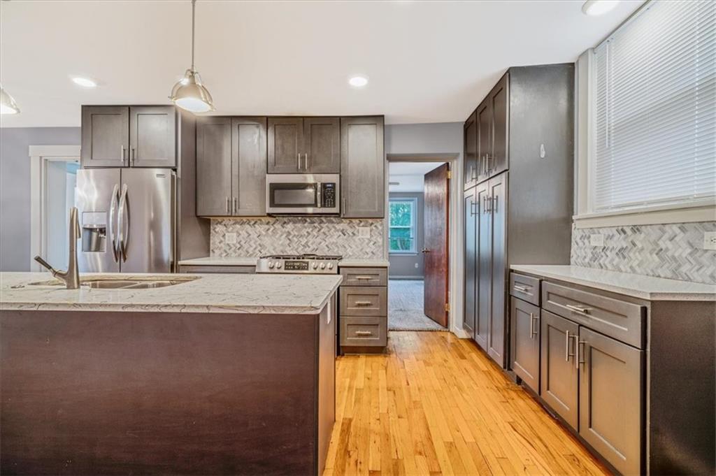 200 Spring Avenue Pittsburgh, PA 15202 - Photo 20 of 43 a kitchen with kitchen island granite countertop a stove refrigerator and cabinets