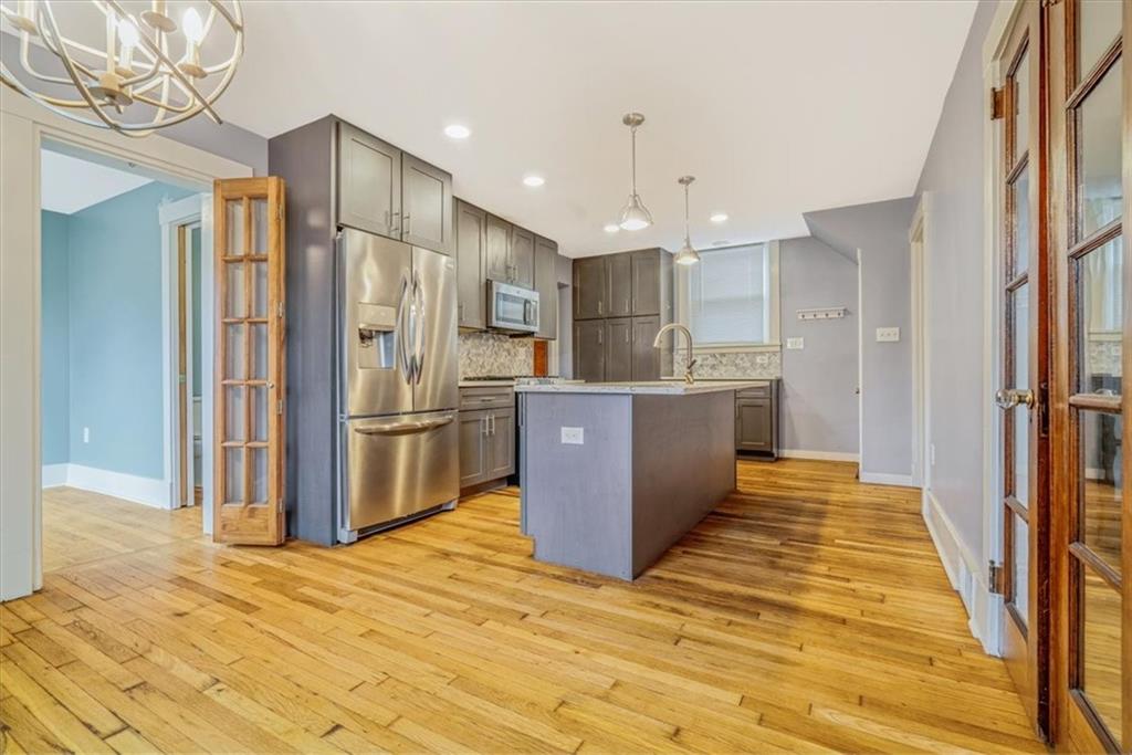 200 Spring Avenue Pittsburgh, PA 15202 - Photo 21 of 43 a kitchen with stainless steel appliances granite countertop a refrigerator and a wooden floor