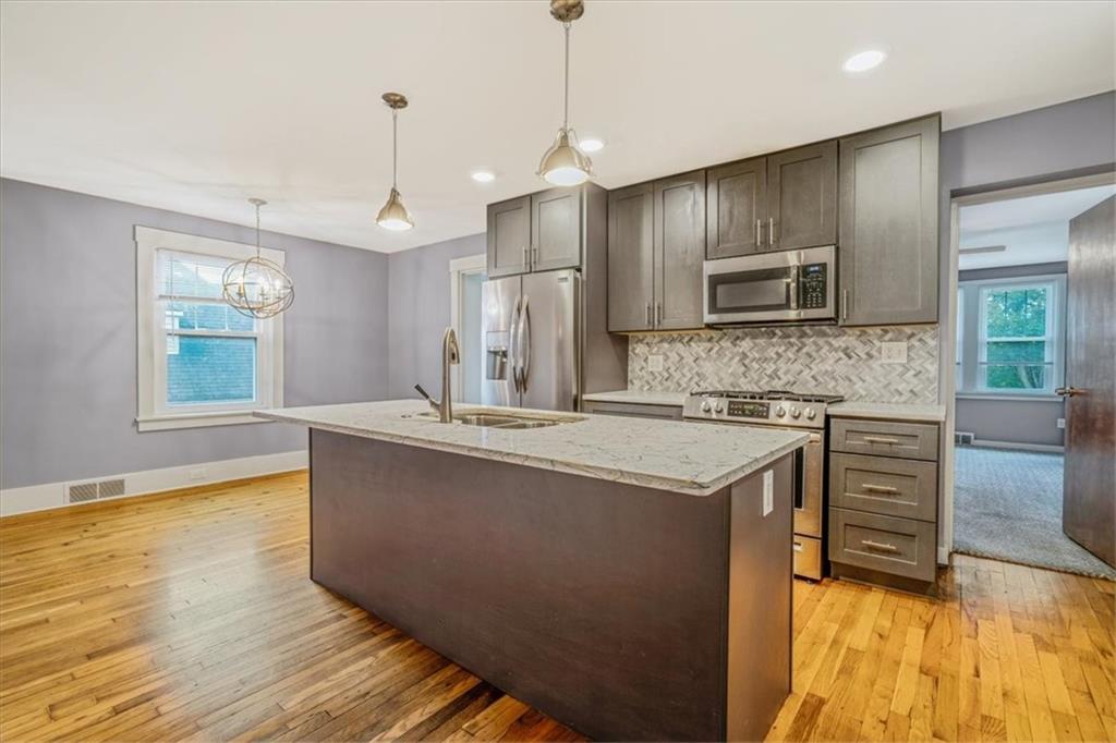 200 Spring Avenue Pittsburgh, PA 15202 - Photo 22 of 43 a kitchen with kitchen island granite countertop a stove top oven a sink with granite countertops and cabinets