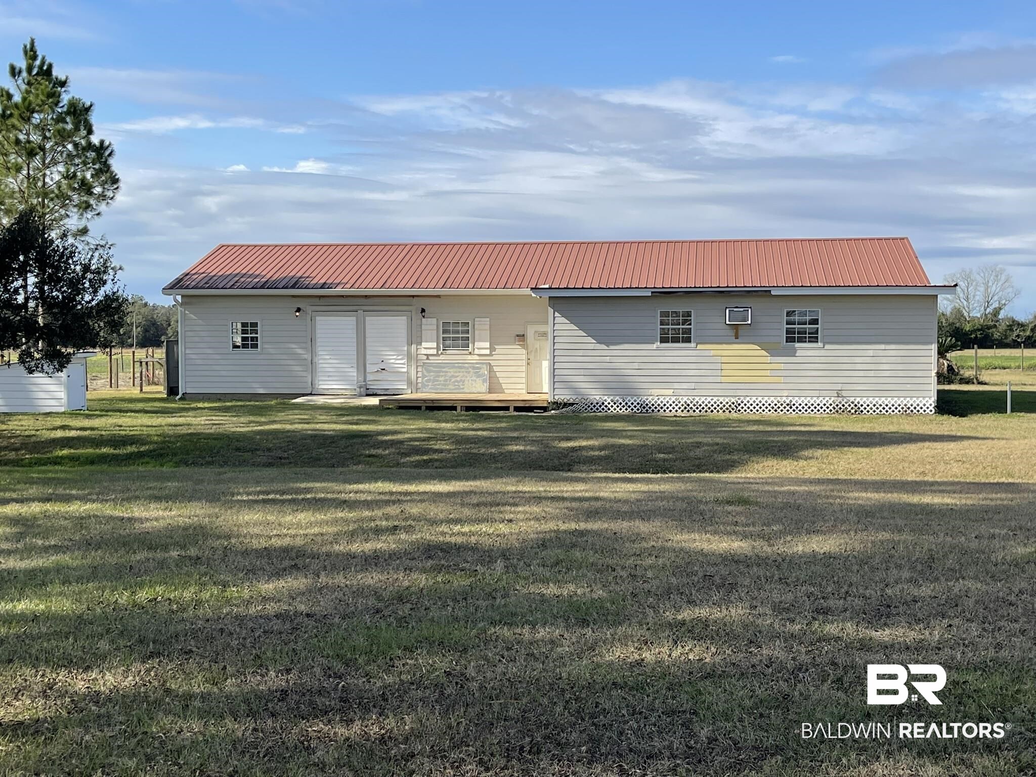 11271 John Bloch Road Elberta, AL 36530 - Photo 3 of 3 Rear view of house featuring a metal roof, a lawn, and covered porch