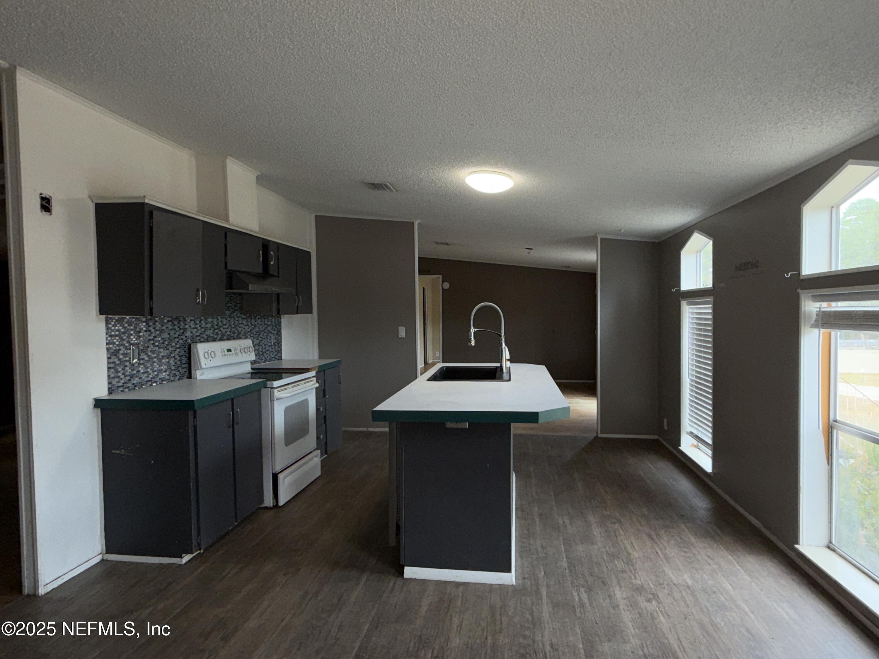 323 Incline Road Satsuma, FL 32189 - Photo 5 of 12 a kitchen with kitchen island stainless steel appliances a sink stove refrigerator and cabinets