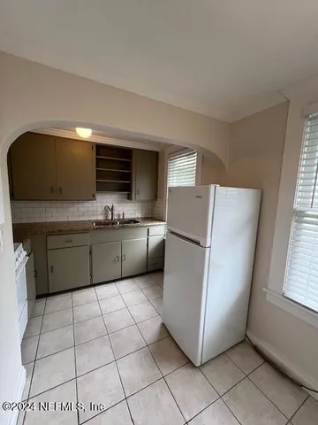 a kitchen with a cabinets a sink a window and stainless steel appliances