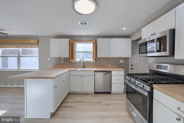 a kitchen with granite countertop a stove top oven sink and cabinets