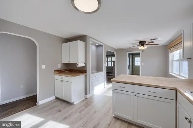 a kitchen with a sink cabinets and wooden floor