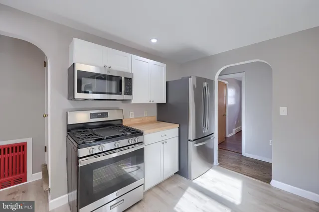 a kitchen with granite countertop a refrigerator stove and microwave