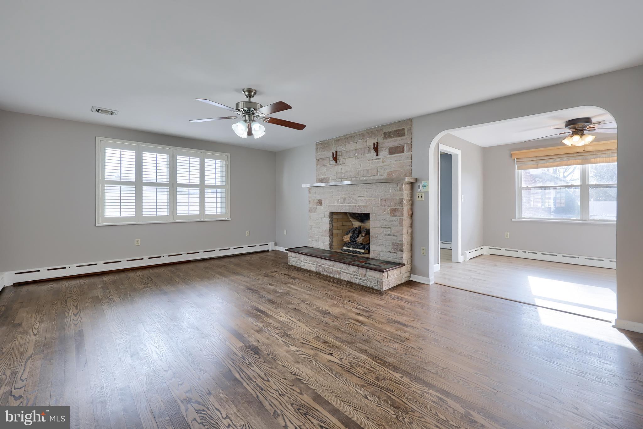 705 Summit Drive Dallastown, PA 17313 - Photo 6 of 50 an empty room with wooden floor fireplace and windows
