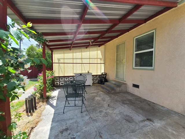 a view of a patio with table and chairs and potted plants