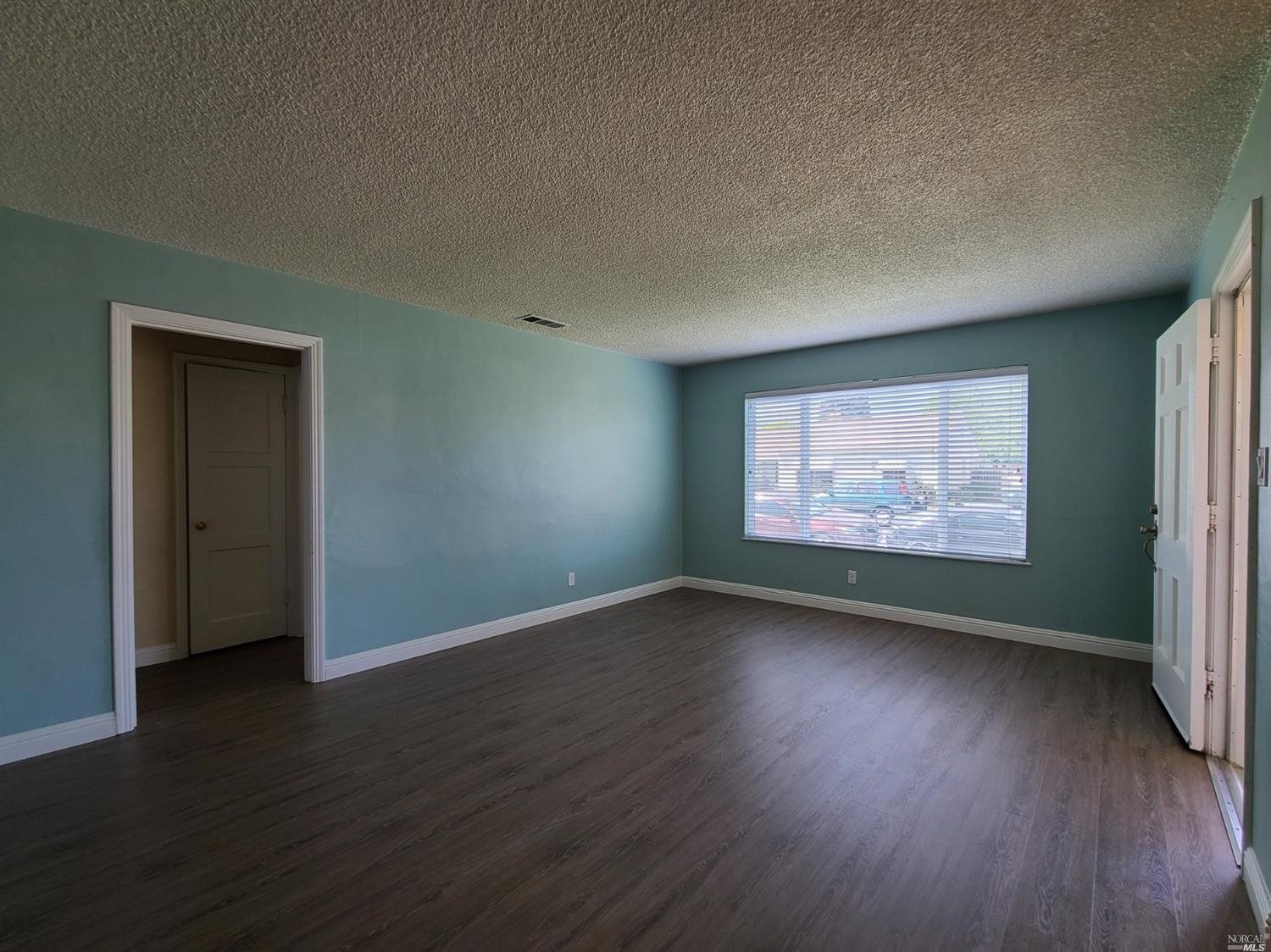 129 Maple Street Vacaville, CA 95688 - Photo 2 of 14 an empty room with wooden floor and windows
