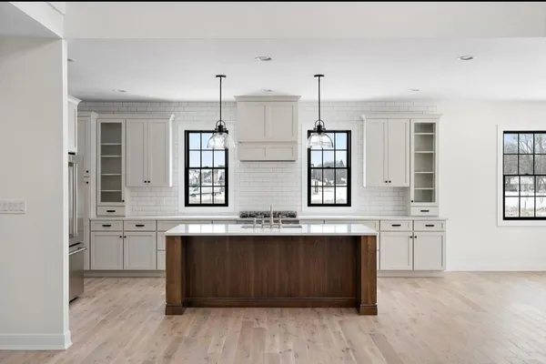 a view of kitchen with stainless steel appliances granite countertop cabinets wooden floor and a window