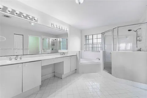 a large bathroom with a large tub sink vanity and granite