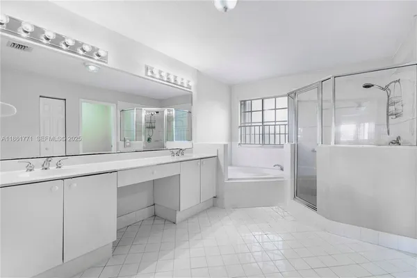 a large bathroom with a large tub sink vanity and granite