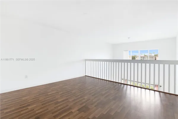 a view of a black and white wall with wooden floor