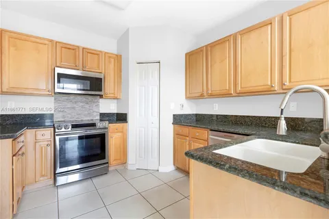 a kitchen with granite countertop a sink and a stove top oven