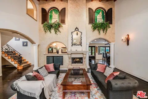 a living room with furniture fireplace and wooden floor