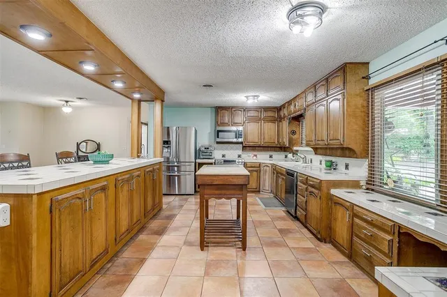a large kitchen with stainless steel appliances lots of counter top space