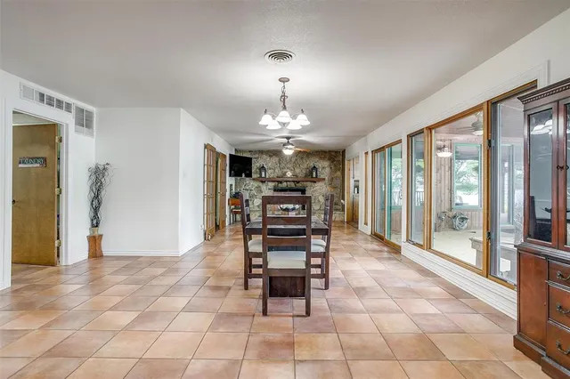 a view of an empty room with window and chandelier fan