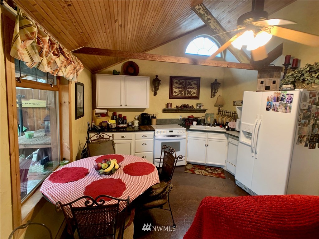 8123 James Road Southwest Rochester, WA 98579 - Photo 29 of 38 a kitchen with a sink a stove and chairs