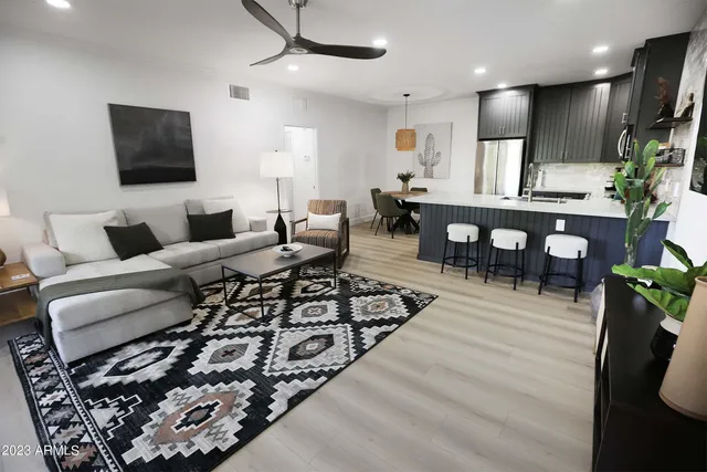 a living room with furniture a flat screen tv and a table