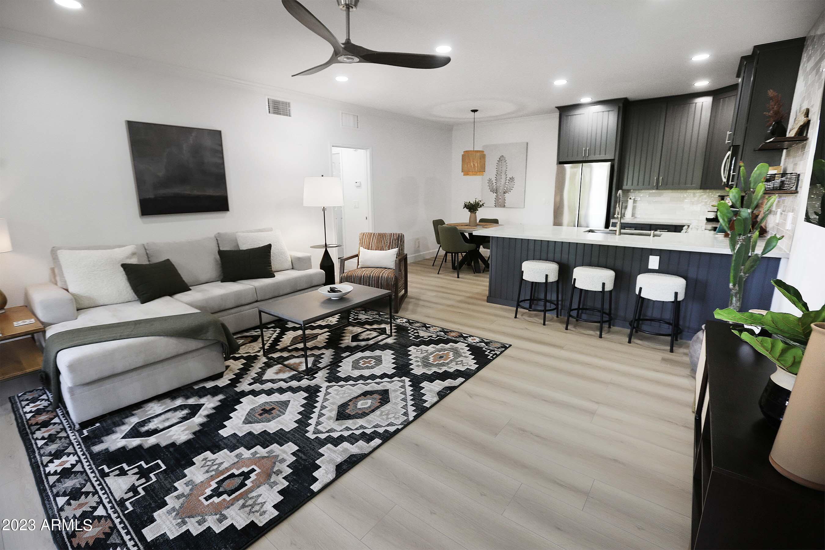 a living room with furniture a flat screen tv and a table