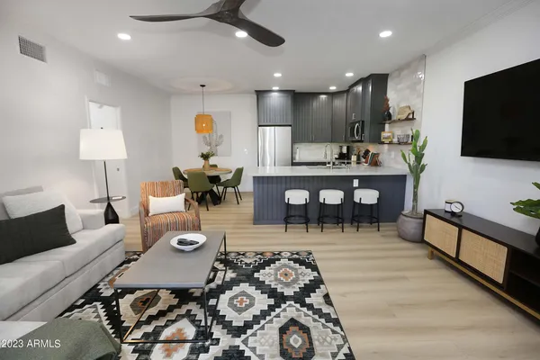 a living room with furniture a flat screen tv and a table