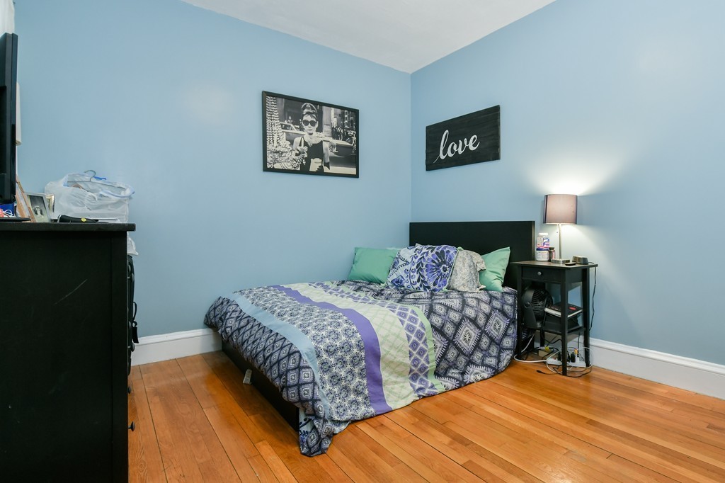 1666 Commonwealth Avenue, Unit 33 Boston, MA 02135 - Photo 4 of 11 a bedroom with bed and wooden floor