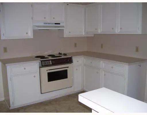 a kitchen with white cabinets and white appliances
