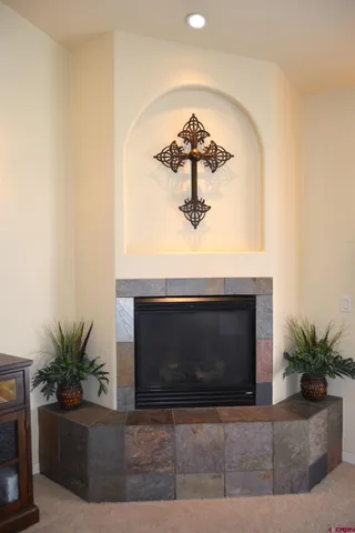 a living room with a fireplace and potted plant