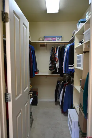 a view of walk in closet with clothes and shoes