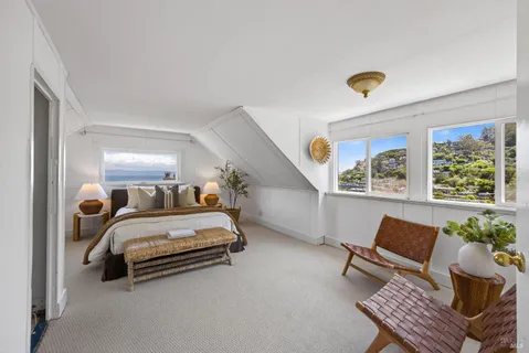 a bedroom with a large bed and a potted plant