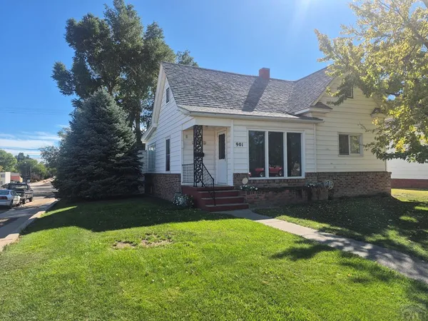 a view of a house with a yard and a patio