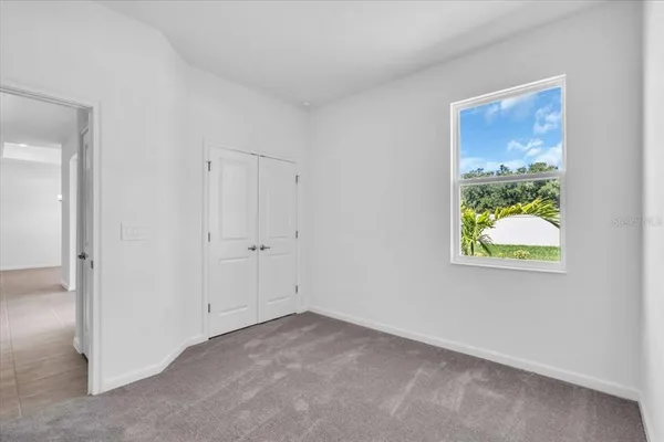 an empty room with closet and windows