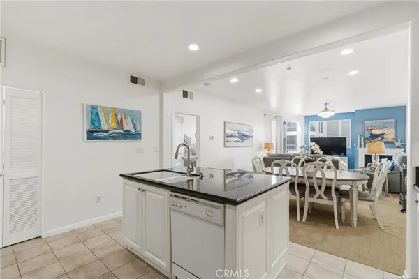 a dining hall with stainless steel appliances granite countertop a table and chairs