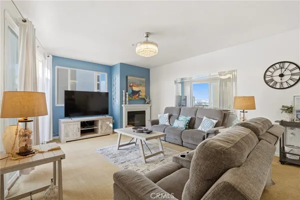 a living room with furniture a flat screen tv and a large window