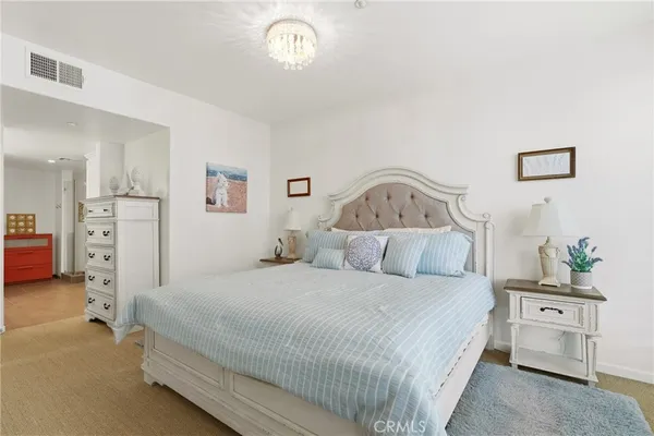 a bedroom with a bed and a chandelier