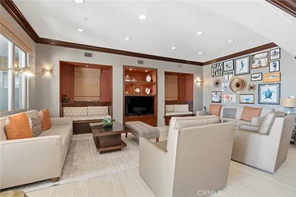 a living room with furniture a flat screen tv and floor to ceiling window