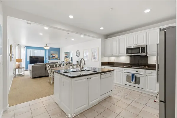 a kitchen with stainless steel appliances kitchen island granite countertop a sink and cabinets