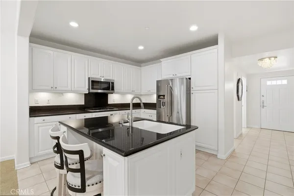 a kitchen with stainless steel appliances granite countertop a sink a stove a refrigerator a microwave a counter top and cabinets