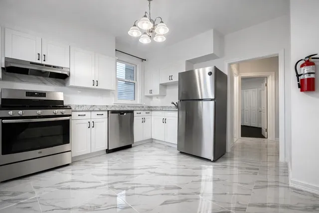 a kitchen with stainless steel appliances granite countertop a stove a refrigerator and a sink