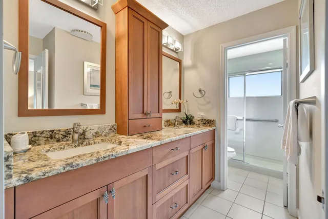 a bathroom with a granite countertop sink and a mirror